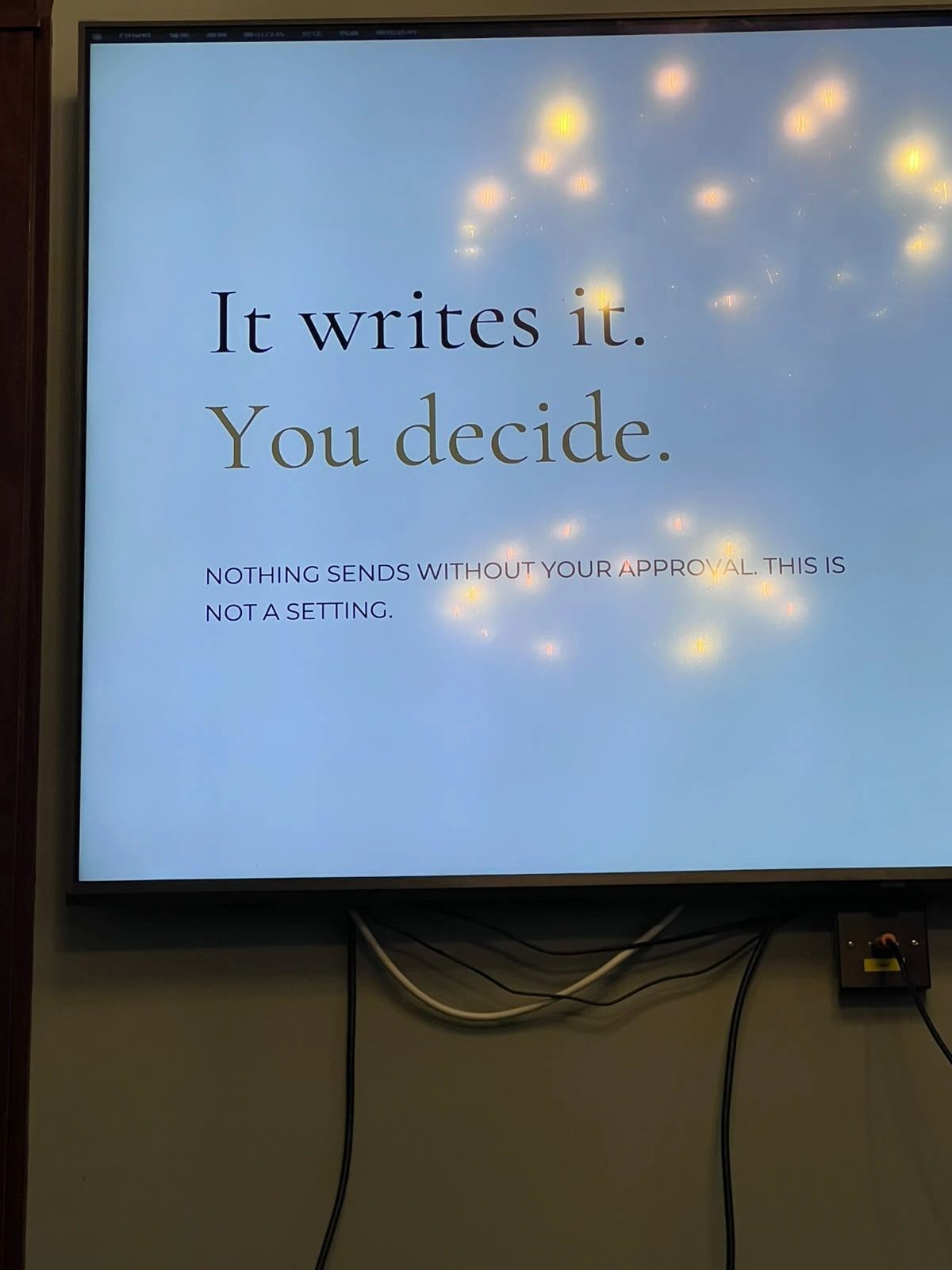 Presentation slide reading: It writes it. You decide. Nothing sends without your approval. This is not a setting.