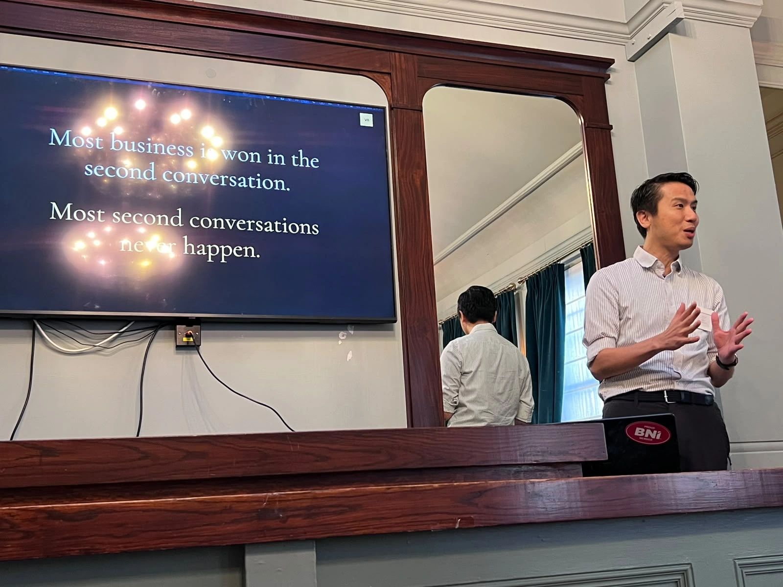 Alan Law presenting Axia at BNI Endeavour in London, with a slide reading: most business is won in the second conversation, most second conversations never happen